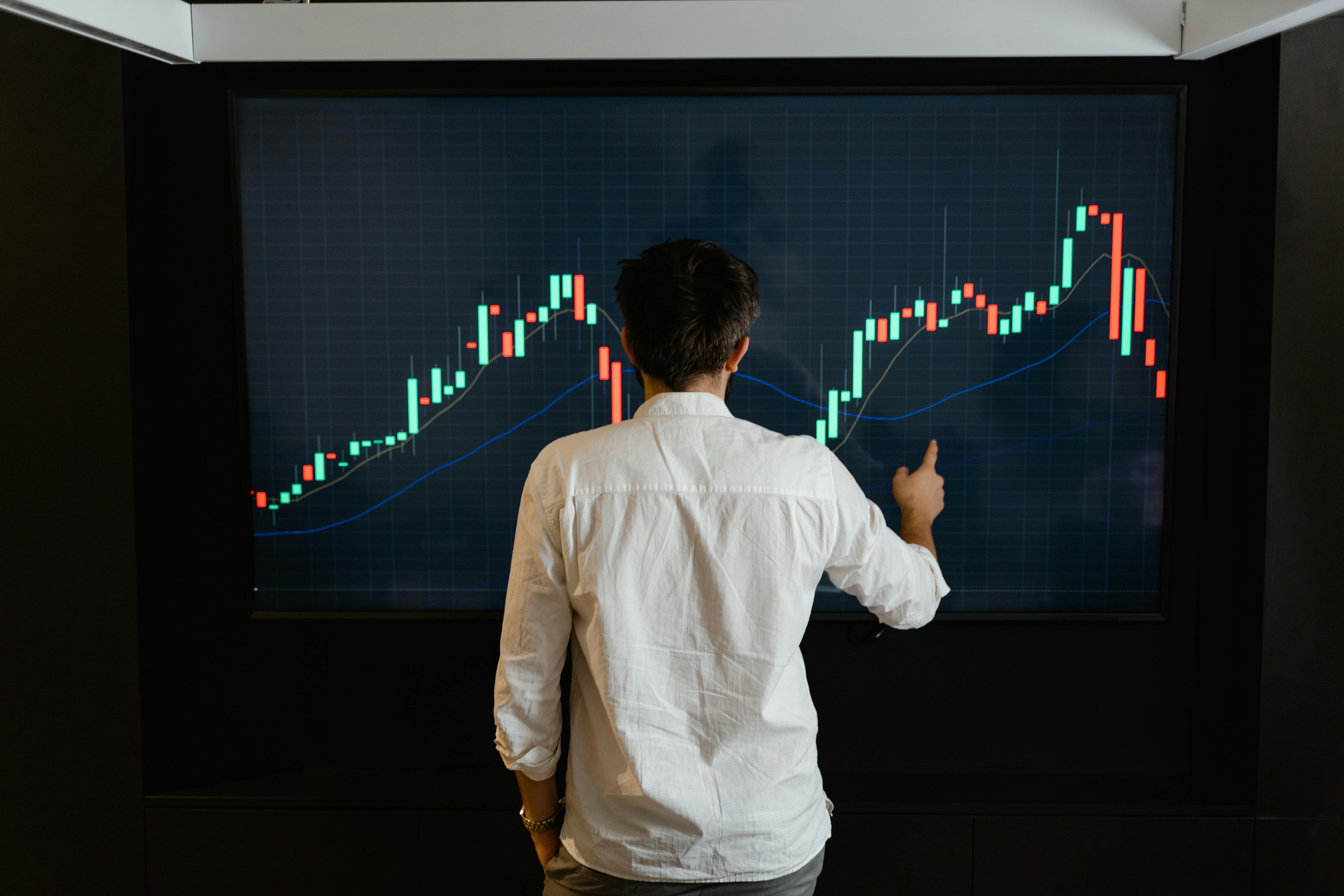 Man standing in front of trading chart